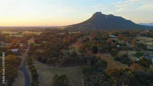 Aerial descend over rural area facing Mount Sturgeon at sunset. Grampians, Victoria, Australia photo