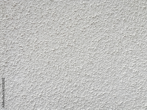 White stucco wall with large bump texture.