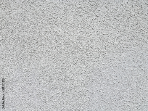White stucco wall with large bump texture.