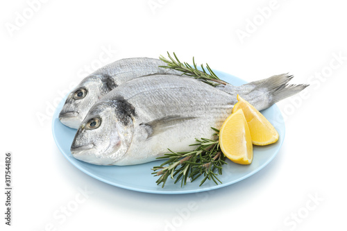Plate with Dorado fishes, lemon and rosemary isolated on white background