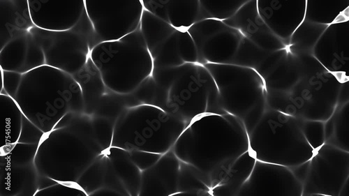 Flowing white rippled shiny light caustic textured pattern on a black pool water abstract background photo