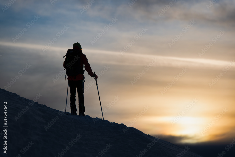 A mountaineer skier watches the sun go down A mountaineer skier watches the sun go down