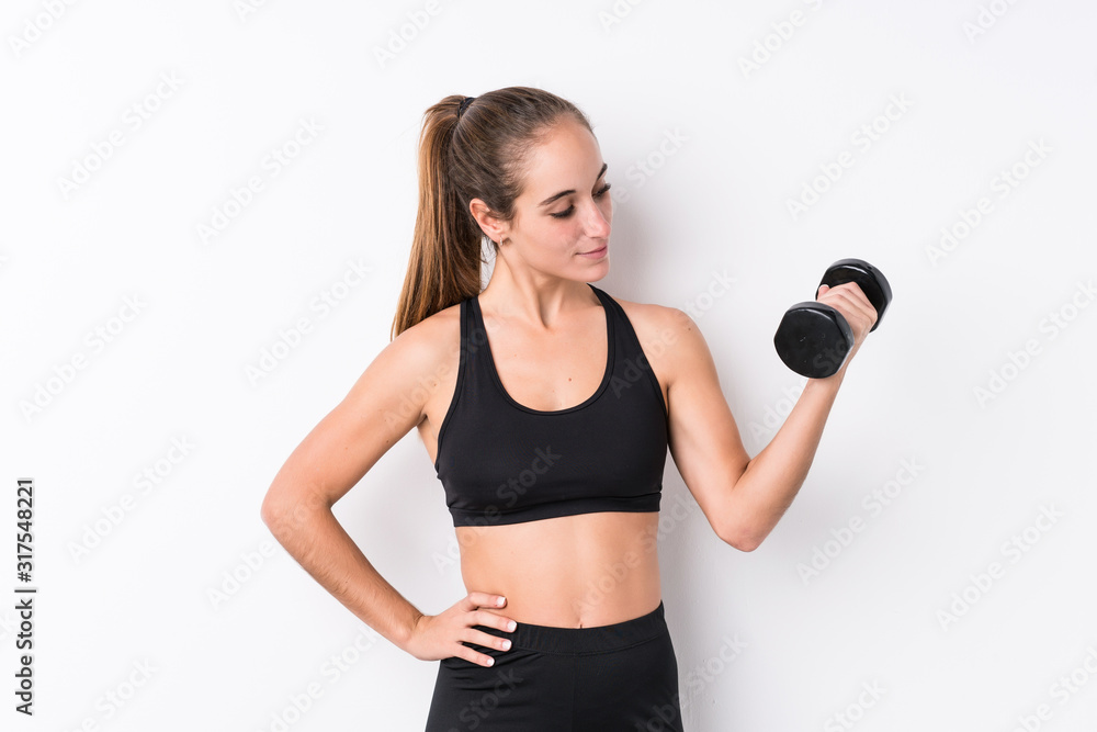 Young caucasian sporty woman holding a dumbbell Young caucasian sporty woman holding a dumbbell