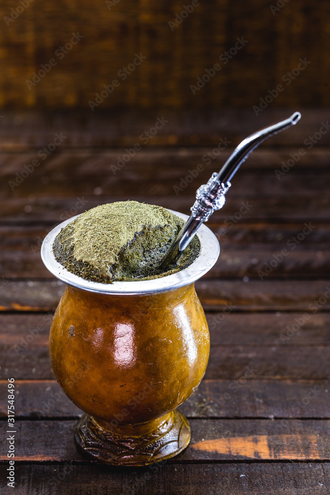 Gaucho yerba mate tea, the chimarrão, a typical Brazilian drink,  traditionally in a bombilla stick cuiade gourd against a wooden background.  Rio Grande do Sul, favorite drink of the gauchos. Stock Photo