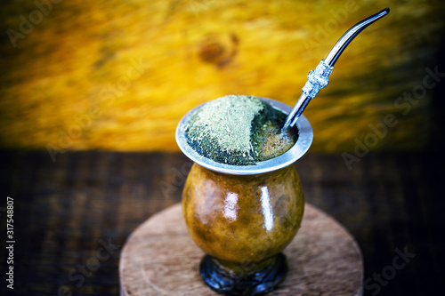 Gaucho yerba mate tea, the chimarrão, a typical Brazilian drink, traditionally in a bombilla stick cuiade gourd against a wooden background. Rio Grande do Sul, favorite drink of the gauchos.