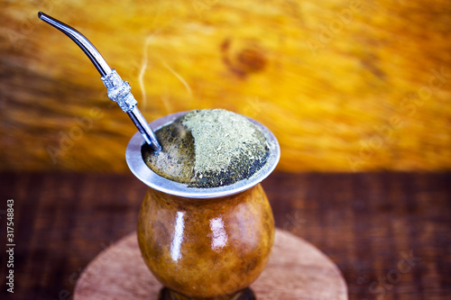 Gaucho yerba mate tea, the chimarrão, a typical Brazilian drink, traditionally in a bombilla stick cuiade gourd against a wooden background. Rio Grande do Sul, favorite drink of the gauchos.