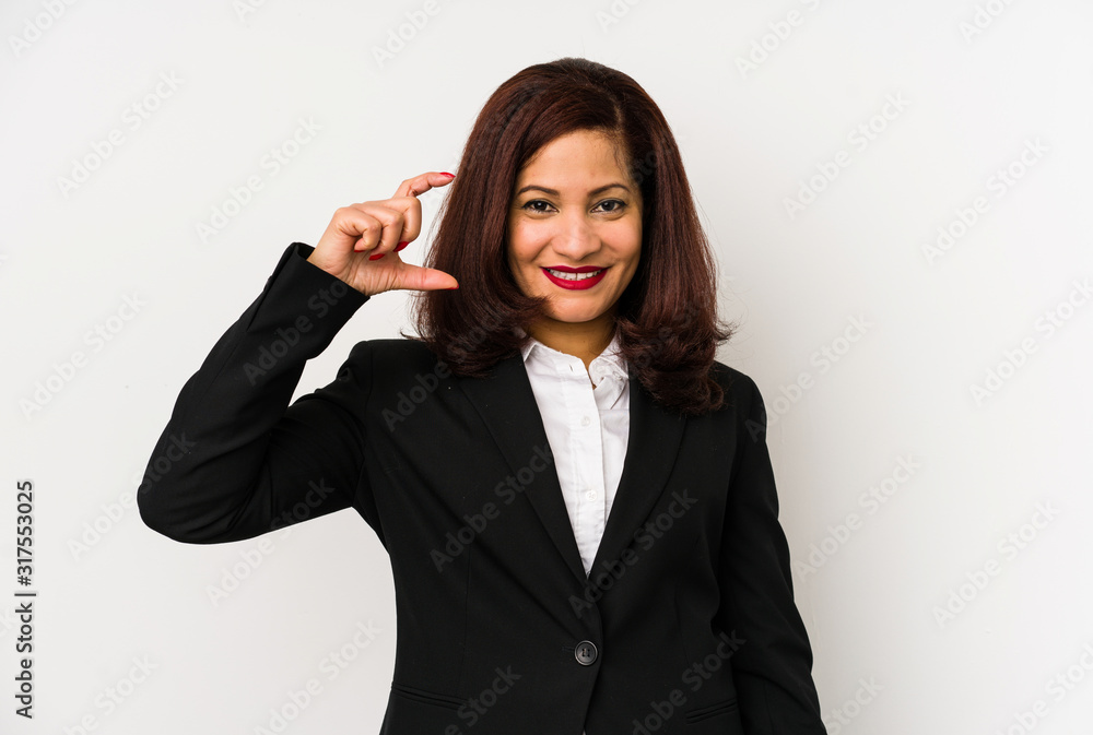 Middle age latin business woman isolated holding something little with forefingers, smiling and confident. Middle age latin business woman isolated holding something little with forefingers, smiling and confident.