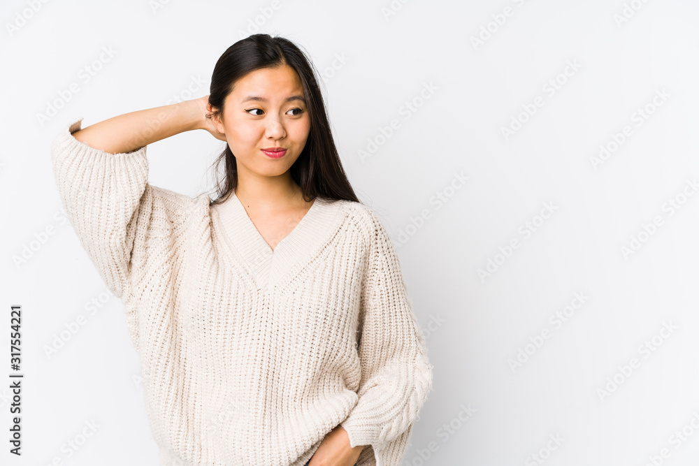 Young chinese woman isolated touching back of head, thinking and making a choice. Young chinese woman isolated touching back of head, thinking and making a choice.