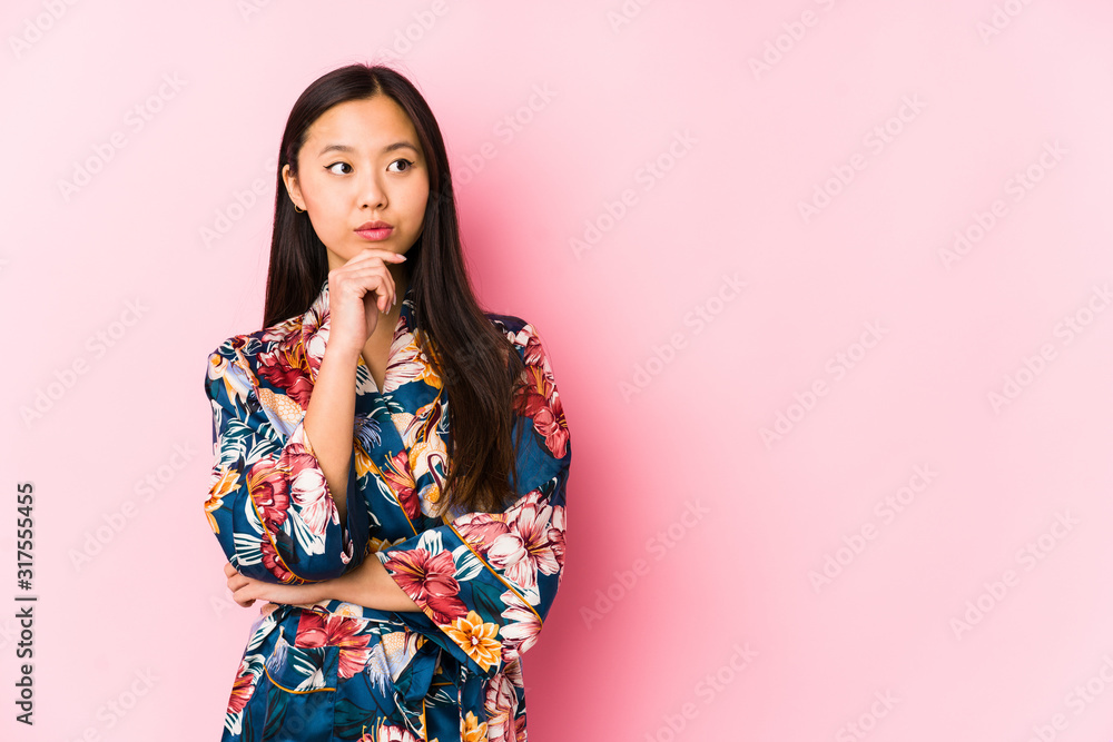 Young chinese woman wearing a kimono pajama isolated looking sideways with doubtful and skeptical expression. Young chinese woman wearing a kimono pajama isolated looking sideways with doubtful and skeptical expression.
