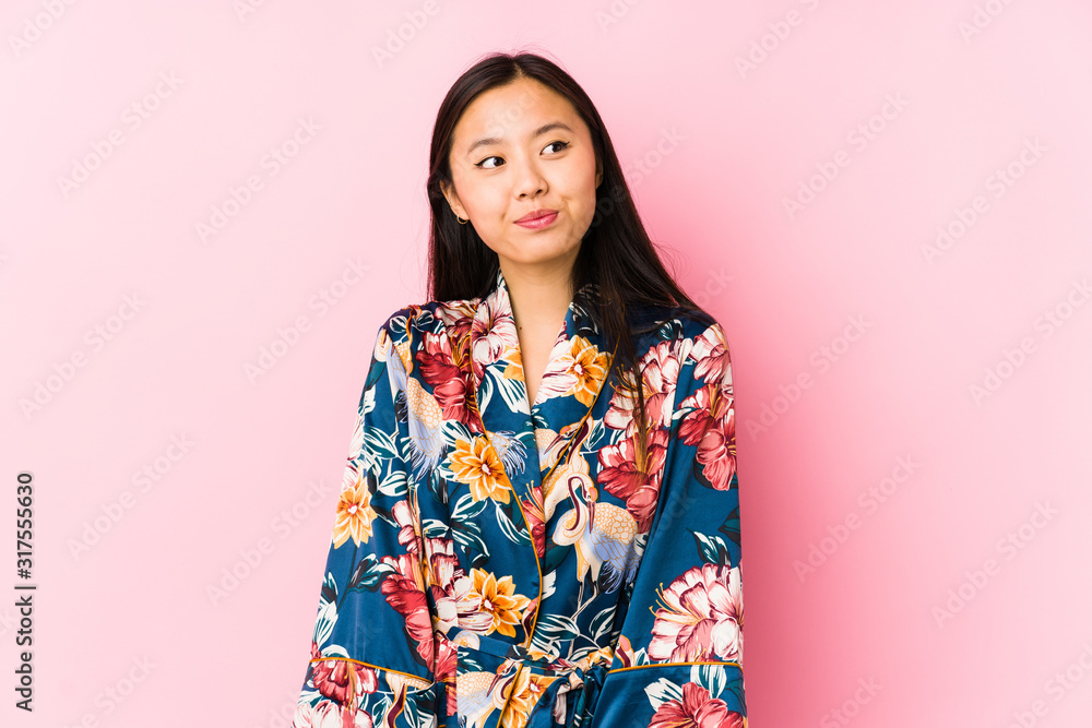Young chinese woman wearing a kimono pajama isolated dreaming of achieving goals and purposes Young chinese woman wearing a kimono pajama isolated dreaming of achieving goals and purposes
