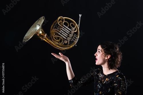 Porträt einer jungen Hornistin eines Philharmonischen Orchesters mit ihrem Instrument
