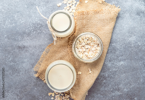 Vegan oat flakes milk  non dairy alternative milk in glass  top view  copy space