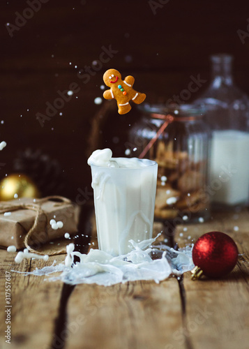 Christmas cookies falling into a glass with milk