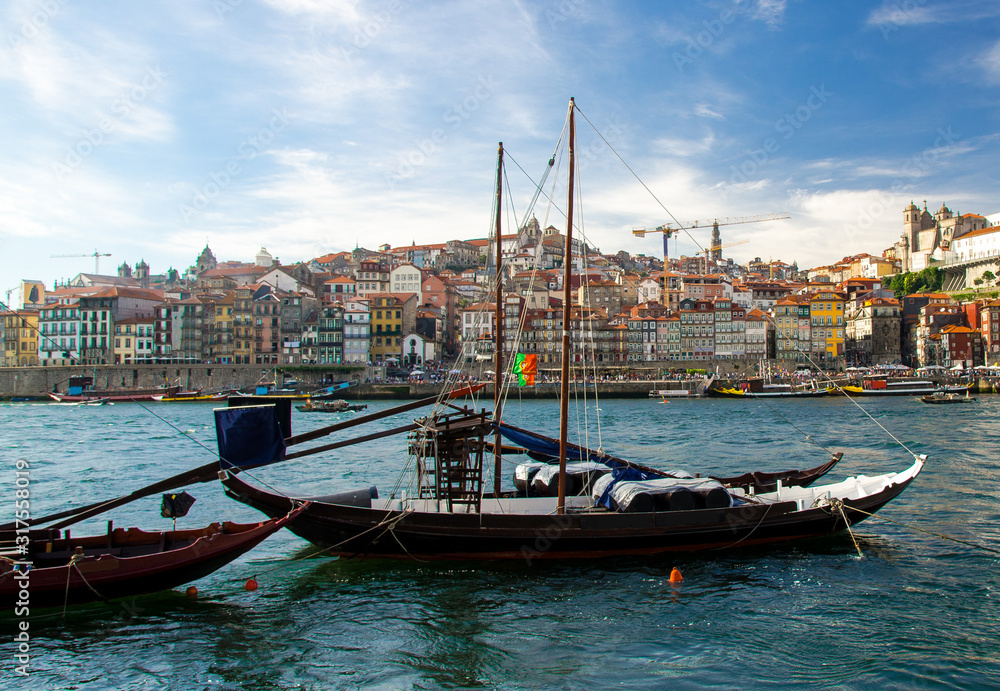 Portugal, Porto, colored houses of old town in Porto, colorful boats on Douro river, Porto by river, Porto old town view, blue wooden boats on the river, portuguese flag on karma of boat