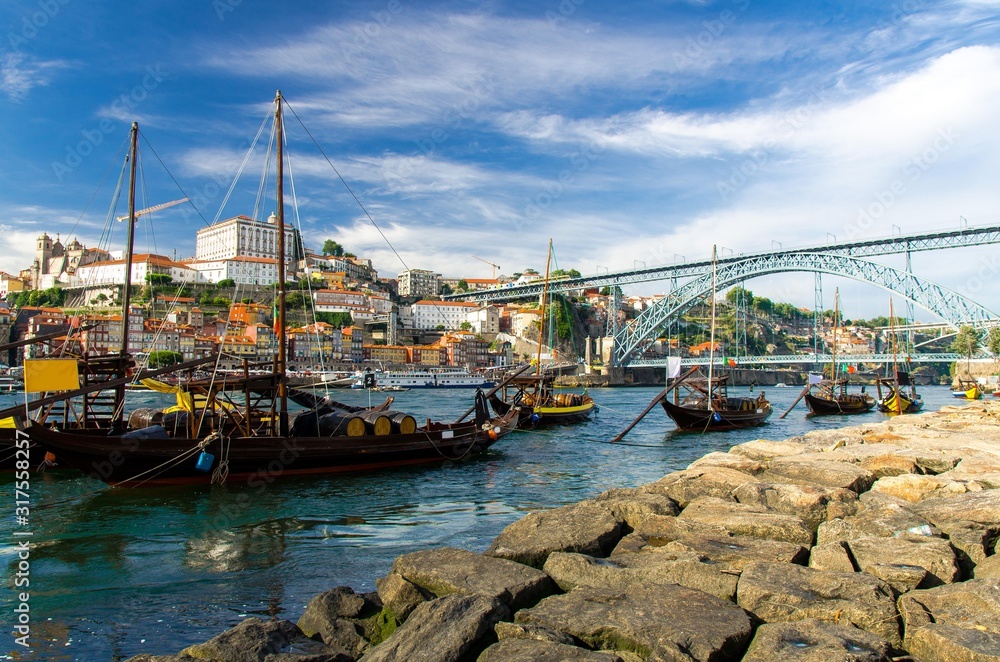 Portugal, city landscape Porto, a group of yellow wooden boats with wine port barrels on Douro river, panoramic view of the old town Porto, The Eiffel Bridge view, Ponte Dom Luis, stone embankment Portugal, city landscape Porto, a group of yellow wooden boats with wine port barrels on Douro river, panoramic view of the old town Porto, The Eiffel Bridge view, Ponte Dom Luis, stone embankment