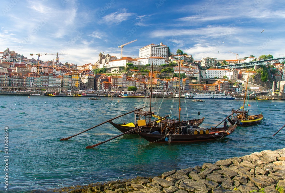 Portugal, city landscape Porto, wooden boats with wine port barrels close up on Douro, panoramic view of the old town Porto, Porto in summer, colored houses, stone embankment of Douro river