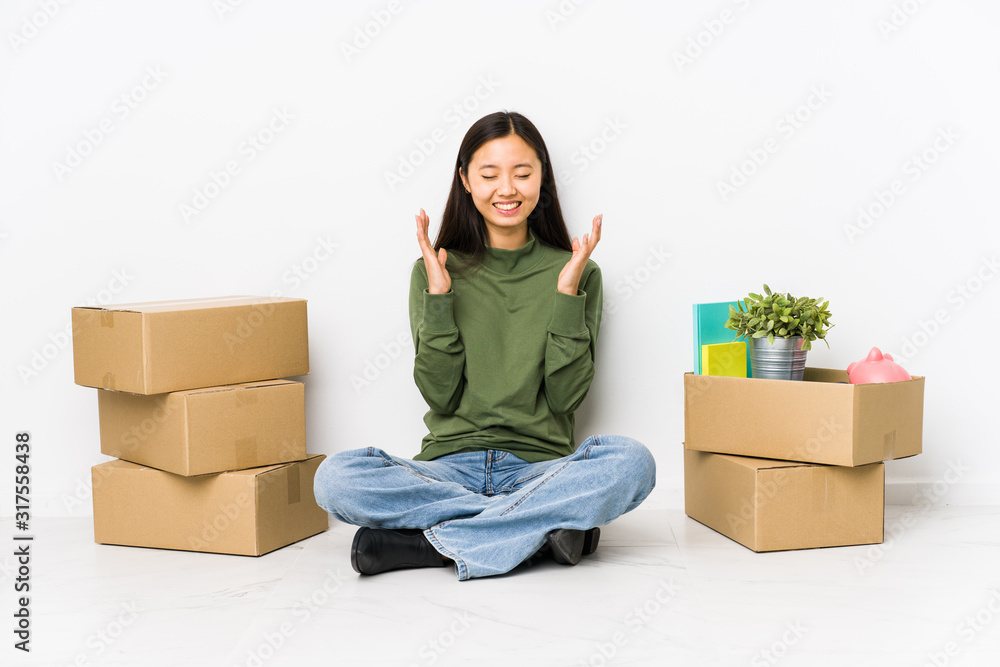 Young chinese woman moving to a new home joyful laughing a lot. Happiness concept. Young chinese woman moving to a new home joyful laughing a lot. Happiness concept.