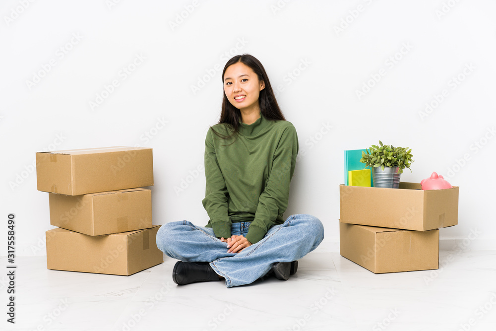 Young chinese woman moving to a new home looks aside smiling, cheerful and pleasant. Young chinese woman moving to a new home looks aside smiling, cheerful and pleasant.