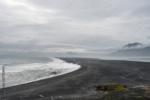 View over Atlantic ocean and Hvalnes beach next to the Ring road in Iceland. Tourists walks on the beach.
