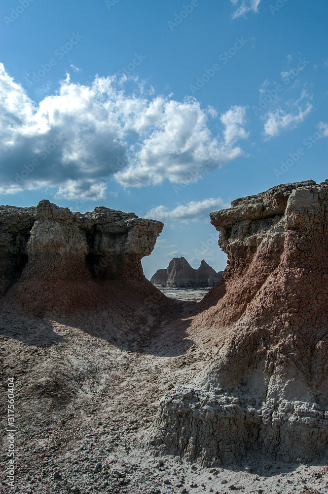 Distance pinnacle rock formations viewed through a keyhole like opening in 'The Door' formation in Badlands National Park, South Dakokta, USA.