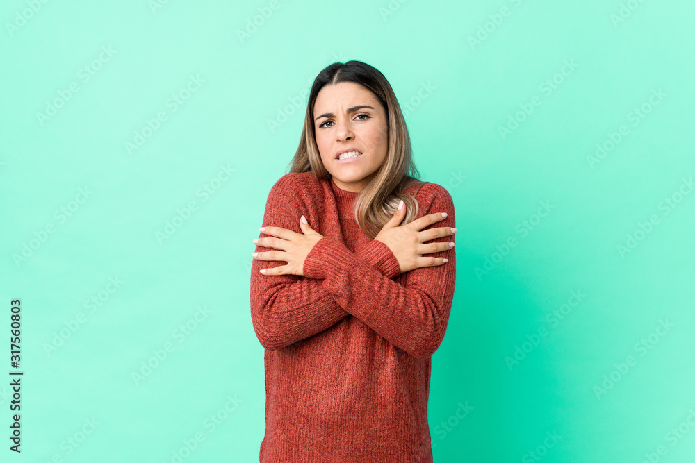 Young caucasian woman isolated going cold due to low temperature or a sickness. Young caucasian woman isolated going cold due to low temperature or a sickness.