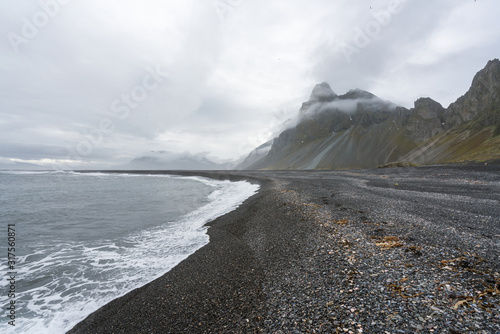 View over Eystrahorn mountain chain and Hvalnes beach next to the Ring road in Iceland. Foggy and overcast weather. Traveling and icelandic concept. photo