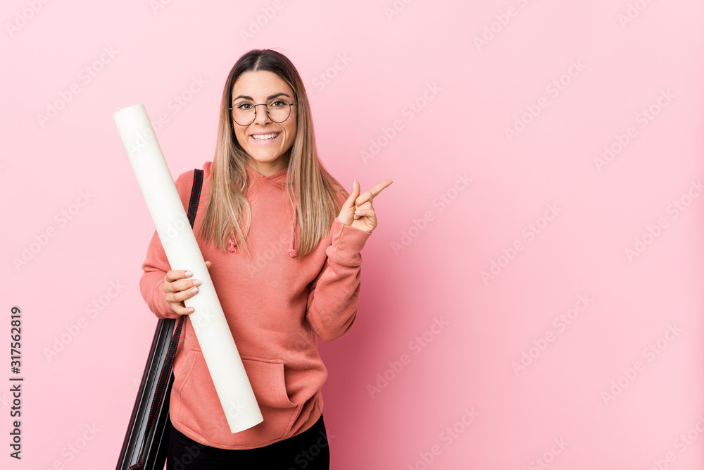 Young woman studying architecture smiling and pointing aside, showing something at blank space. Young woman studying architecture smiling and pointing aside, showing something at blank space.