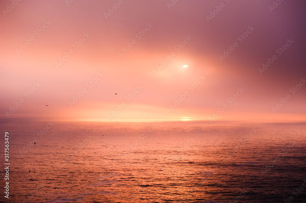 Beautiful sunset in Atlantic ocean near the coast of Algarve, Portugal. Colorful nature background