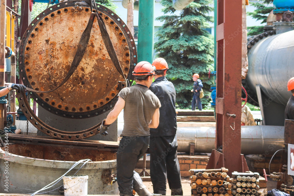 Male workers assemblers mount a shell-and-tube heat exchanger, repair ...
