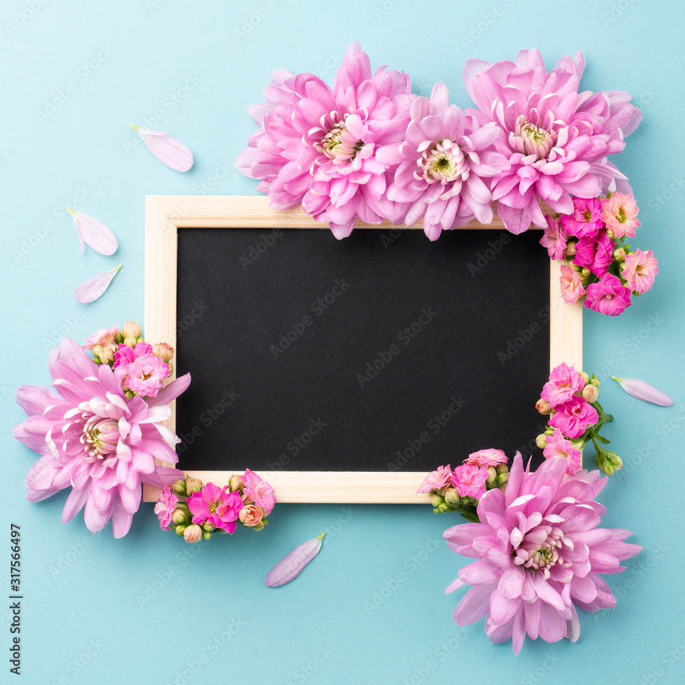 Happy Valentine Day. Pink flowers and chalkboard frame on blue background. Top view. Space for text. Happy Valentine Day. Pink flowers and chalkboard frame on blue background. Top view. Space for text.