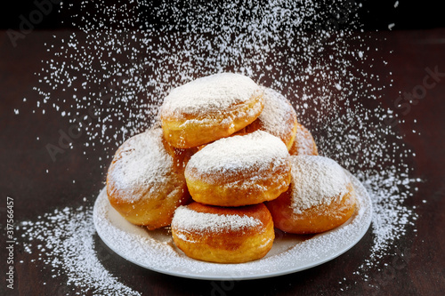 Fototapeta Homemade american donuts sprinkling with powder sugar.