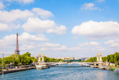 Cityscape of Paris, France, with the Alexandre III bridge over the river Seine, the Eiffel tower on the left and the Chaillot palace in the distance by a sunny summer day.