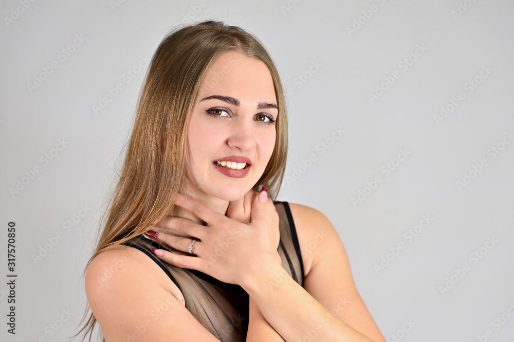 A large photo of a pretty smiling girl with long hair and excellent make-up is standing in different poses. Generic female portrait concept for cosmetics advertising on a white background. A large photo of a pretty smiling girl with long hair and excellent make-up is standing in different poses. Generic female portrait concept for cosmetics advertising on a white background.