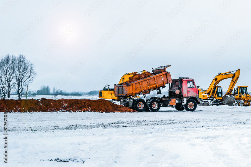 Excavator is loading excavation to the truck. Excavators hydraulic are heavy construction equipment consisting of a boom, dipper or stick , bucket and cab on a rotating platform Excavator is loading excavation to the truck. Excavators hydraulic are heavy construction equipment consisting of a boom, dipper or stick , bucket and cab on a rotating platform