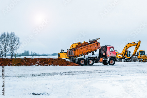 Excavator is loading excavation to the truck. Excavators hydraulic are heavy construction equipment consisting of a boom, dipper or stick , bucket and cab on a rotating platform