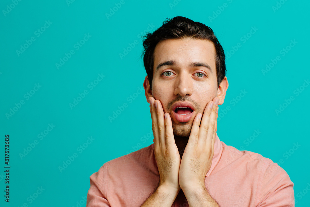 Portrait of a young adult man smiling, isolated on blue studio background Portrait of a young adult man smiling, isolated on blue studio background
