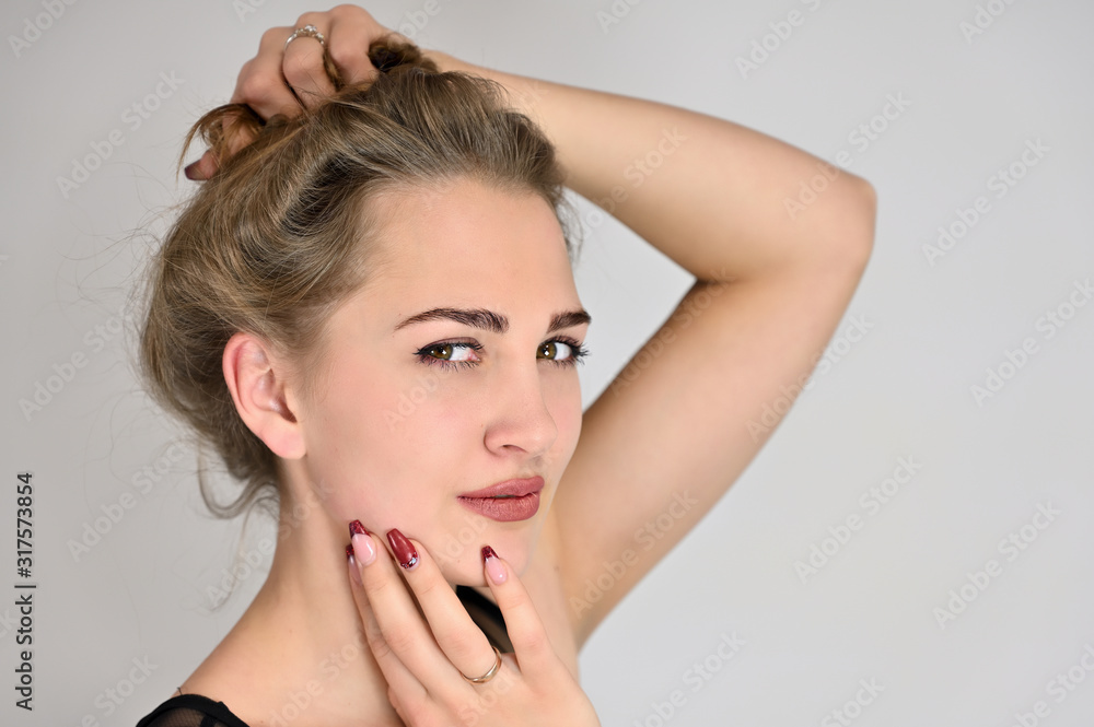 Naklejka premium Generic female portrait concept for cosmetics advertising on a white background. A large photo of a pretty smiling girl with long hair and excellent make-up is standing in different poses.