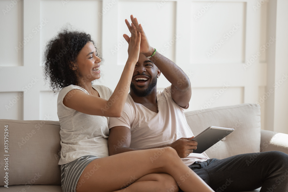 African wife gives high five husband celebrating received fantastic opportunity - obrazy, fototapety, plakaty 