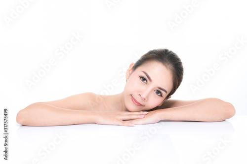 Charming young asian woman with clean fresh skin  Hair sleek  Proposing a product while lying on isolated on white background  Front view  copy space on the top.