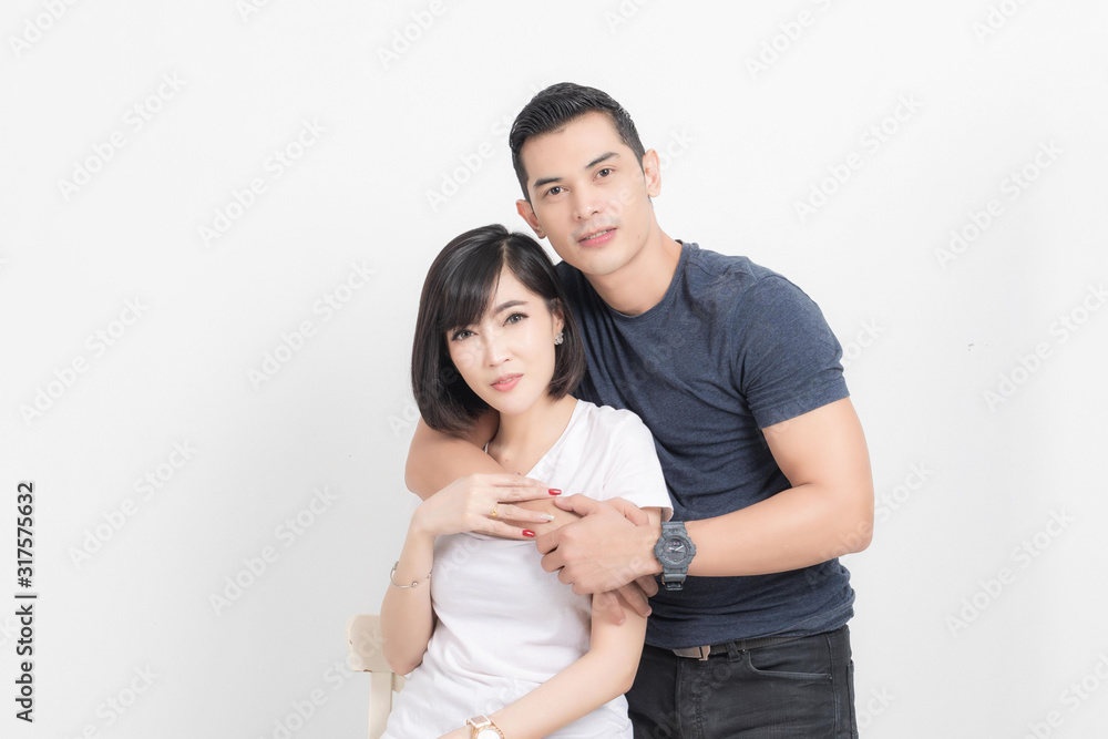 Portrait of happy young couple embracing in studio shot on white background. Portrait of happy young couple embracing in studio shot on white background.