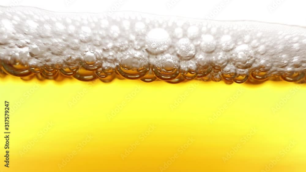 Carbonated drink close-up, macro photo. Above is the foam on which the bubbles burst. Beer, lemonade. Carbonated drink close-up, macro photo. Above is the foam on which the bubbles burst. Beer, lemonade.