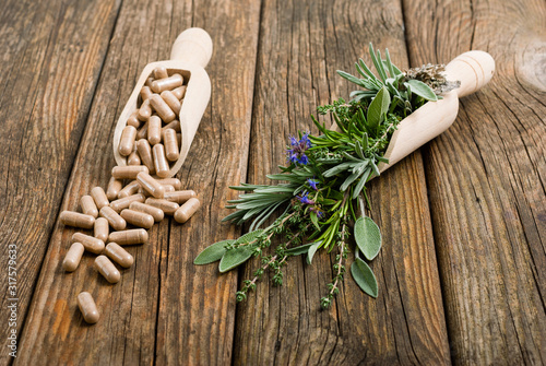 Obraz na plátně herbal plants and medicine capsules on old wooden