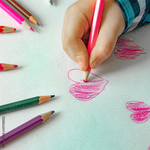 Child are Drawing Red and Colorful Hearts for Mothers Day or Fathers Day or Valentines Day. Birthday