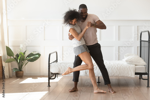 African couple in love holding hands dancing in morning indoors