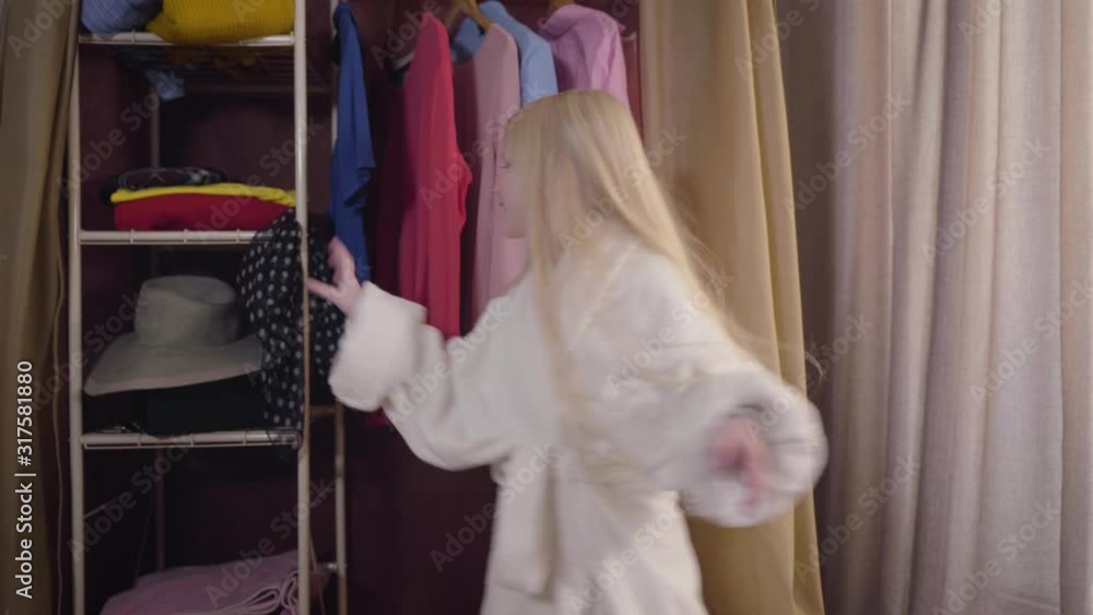 Middle shot of joyful Caucasian girl dancing, taking elegant light scarf and putting it on camera. Cheerful blond kid enjoying weekends indoors. Joy, lifestyle, childhood. Middle shot of joyful Caucasian girl dancing, taking elegant light scarf and putting it on camera. Cheerful blond kid enjoying weekends indoors. Joy, lifestyle, childhood.