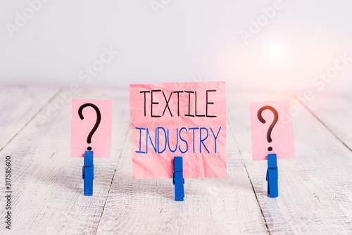 Handwriting text Textile Industry. Conceptual photo production and distribution of yarn cloth and clothing Scribbled and crumbling sheet with paper clips placed on the wooden table photo
