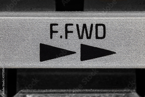 Macro close up photograph of vintage boombox tape machine fast forward button detail.  