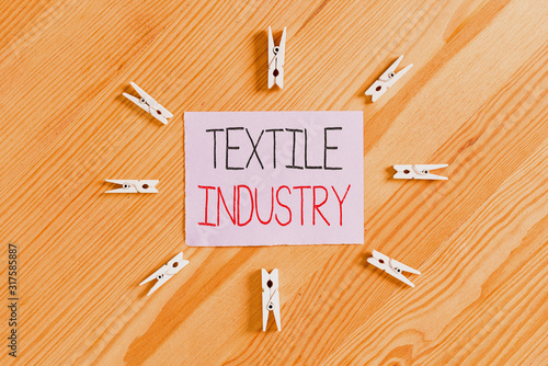 Handwriting text Textile Industry. Conceptual photo production and distribution of yarn cloth and clothing Colored clothespin papers empty reminder wooden floor background office photo