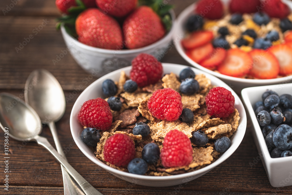 Granola chips with blueberries and raspberries in white bowl. Granola chips with blueberries and raspberries in white bowl.
