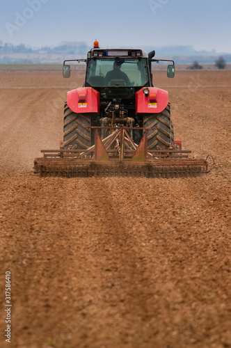 Tracteur passant le vibroculteur (herse rotative)